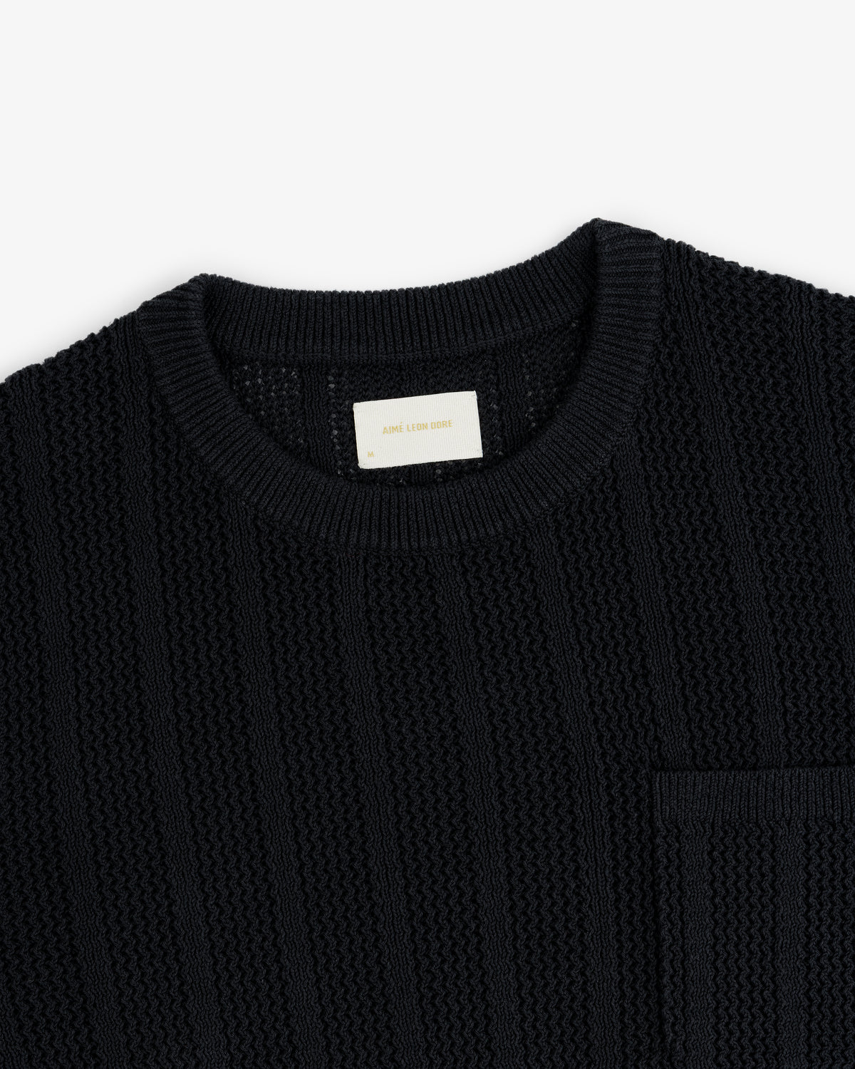 Racking Stitch Crewneck Sweater in black, textured knit with a chest pocket, shown on a white background.