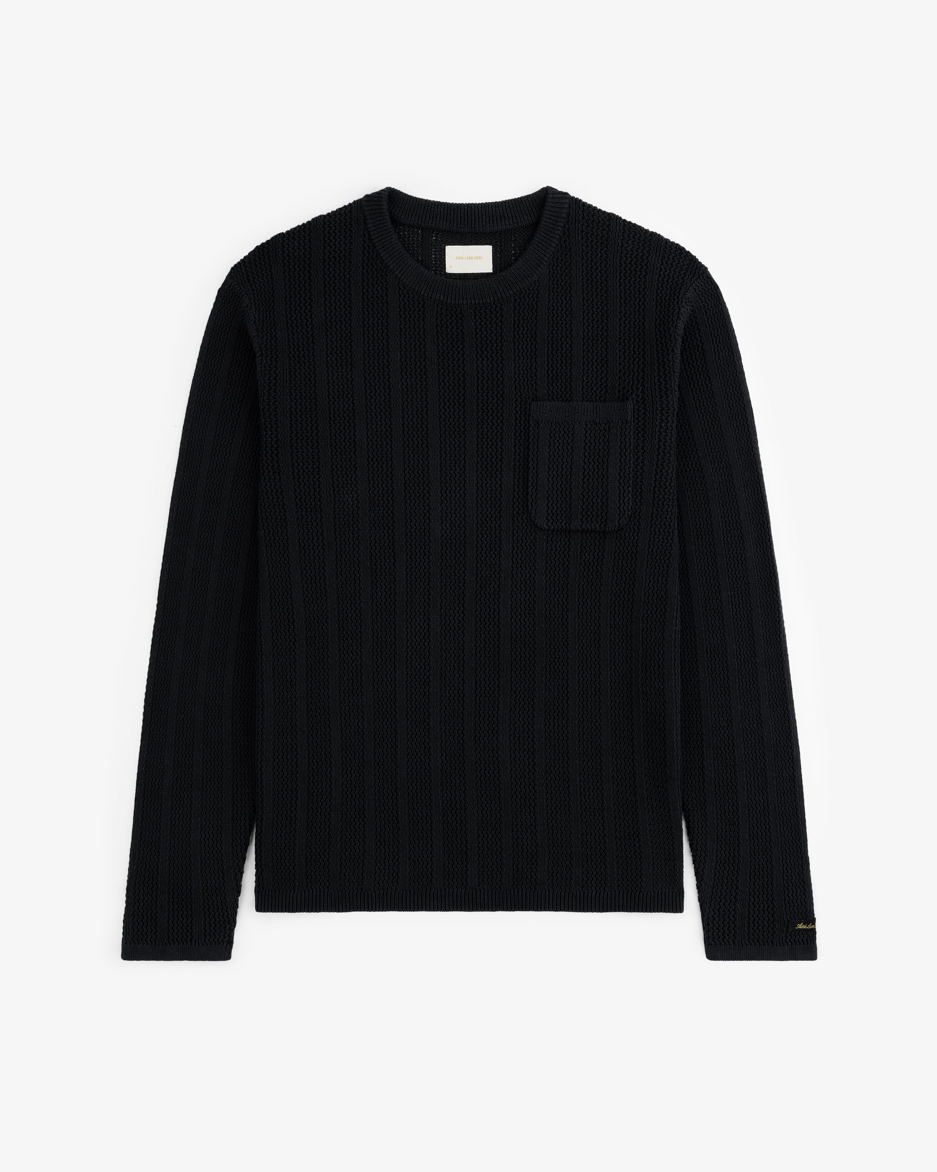 The Racking Stitch Crewneck Sweater in black with long sleeves and chest pocket, shown flat on a white background.