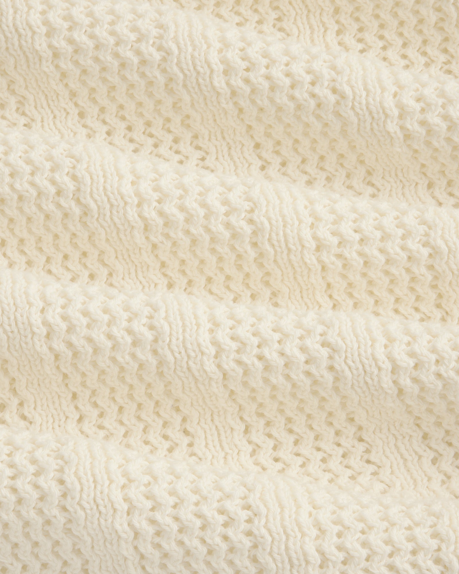 Close-up of the Racking Stitch Crewneck Sweater in cream, showing its textured, wavy knit pattern.
