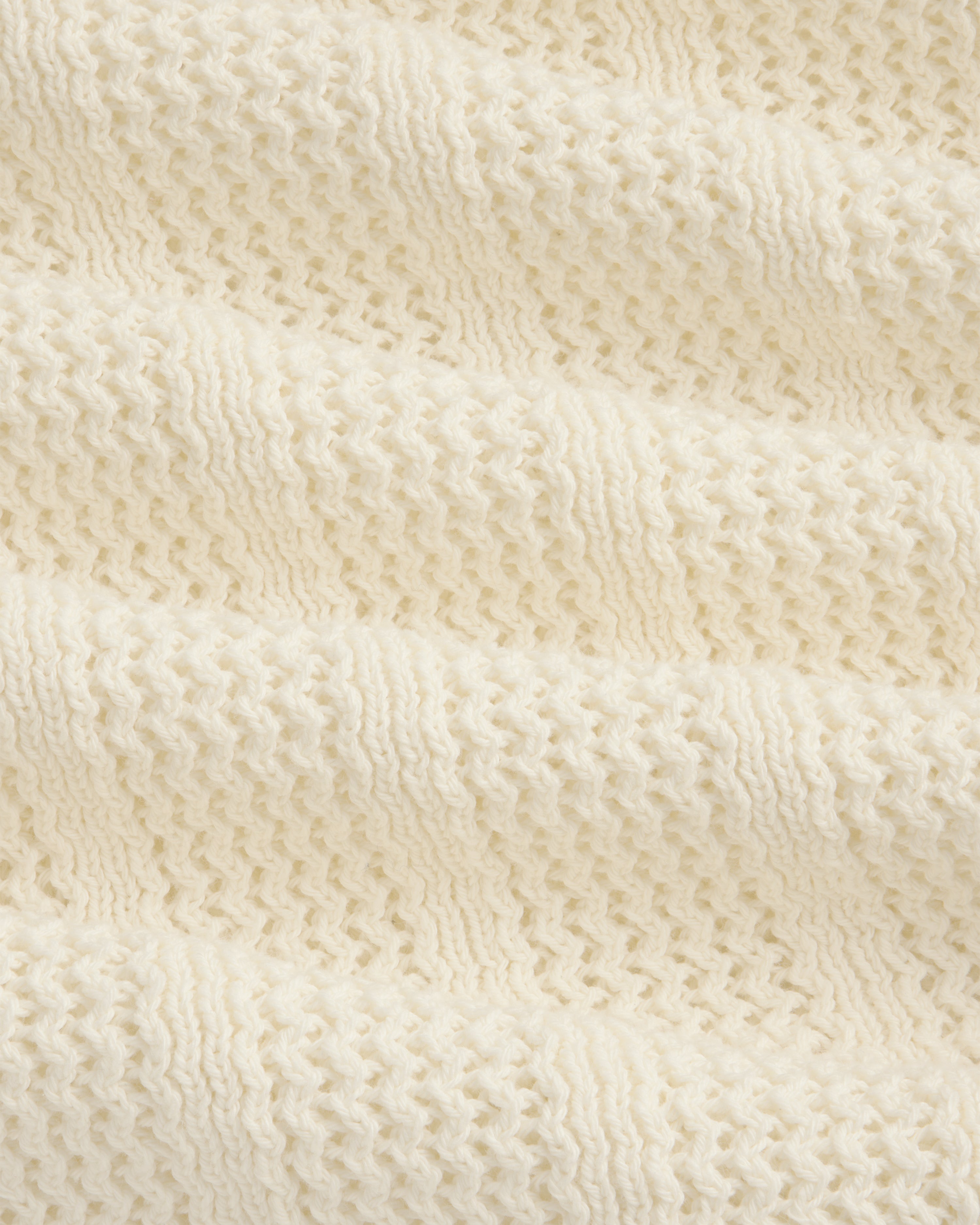 Close-up of the Racking Stitch Crewneck Sweater in cream, showing its textured, wavy knit pattern.