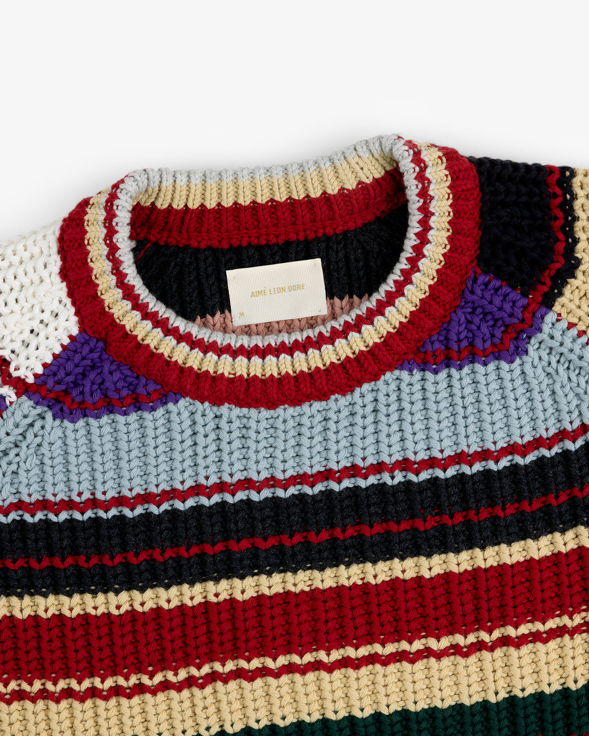 Close-up of the Striped Crewneck Sweater, featuring multicolored stripes and a label on the collar.