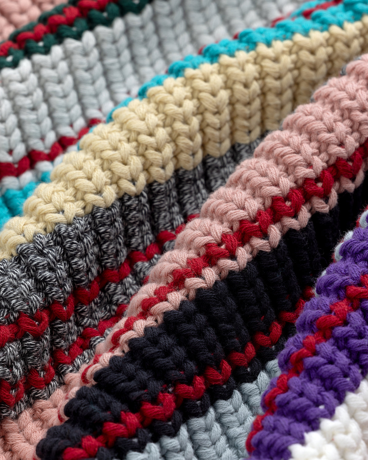 Close-up of the Striped Crewneck Sweater, featuring colorful yarns and textured stripes in various patterns.