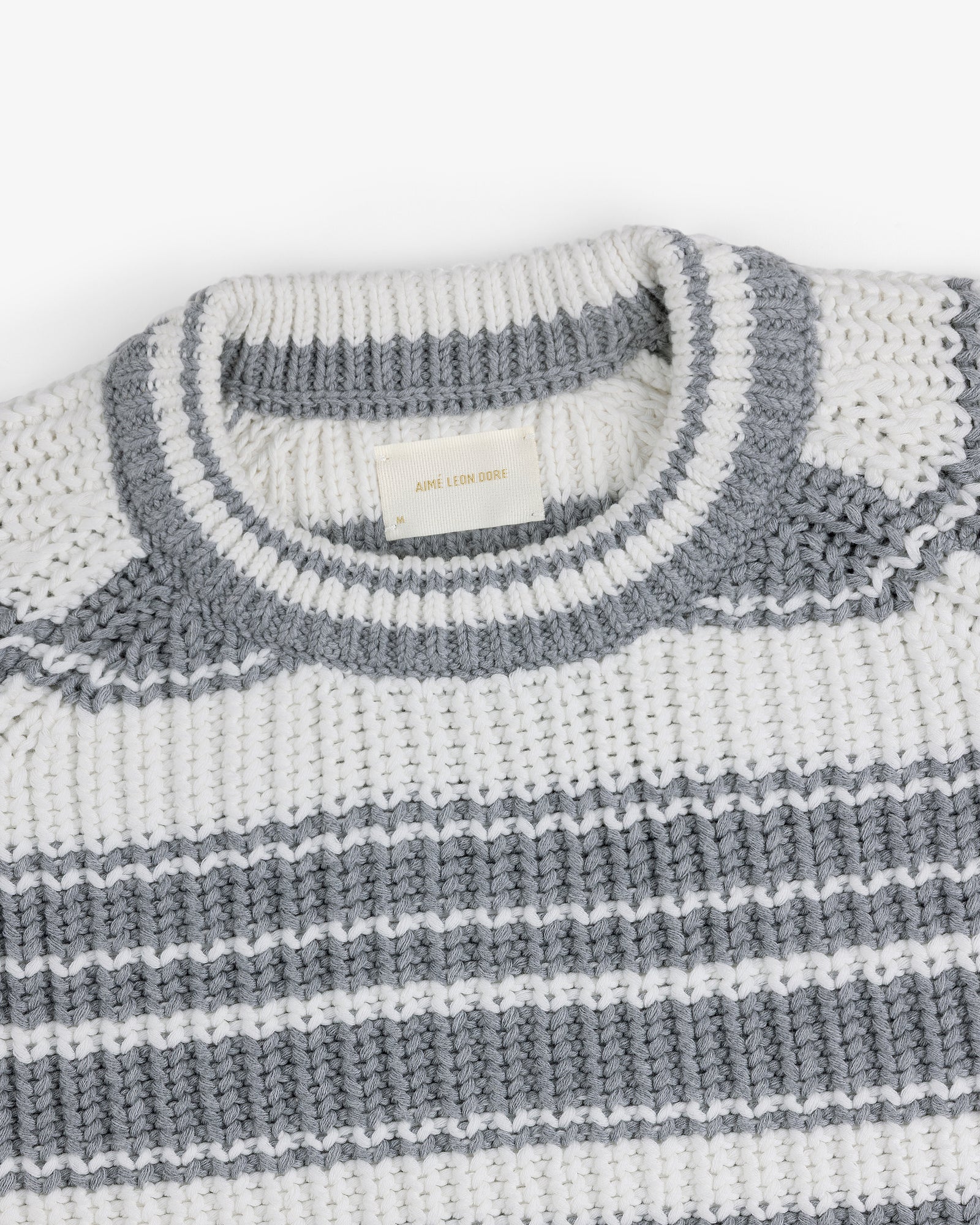 Striped Crewneck Sweater in white with gray stripes and a gray-trimmed neckline, displayed folded.