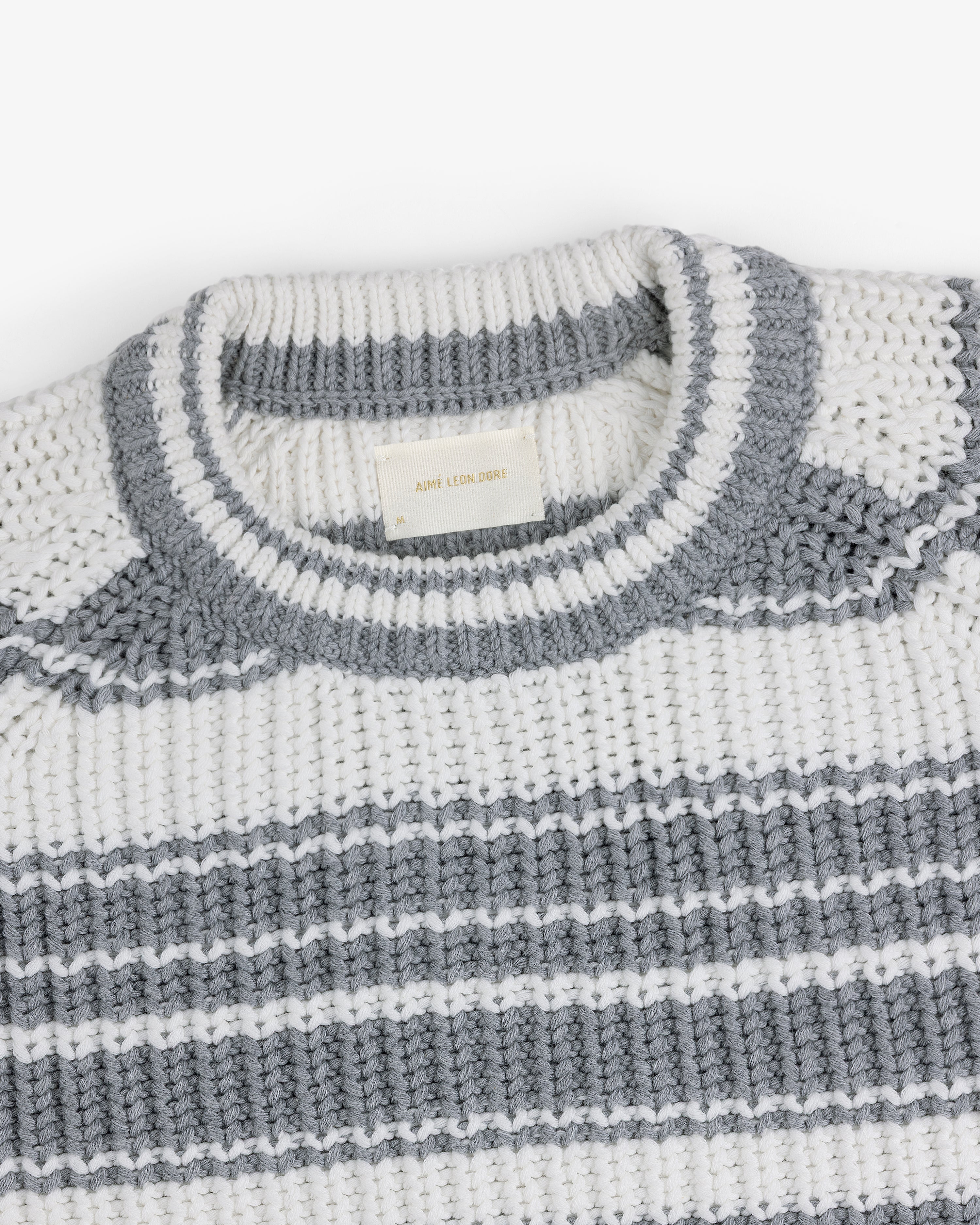 Striped Crewneck Sweater in white with gray stripes and a gray-trimmed neckline, displayed folded.