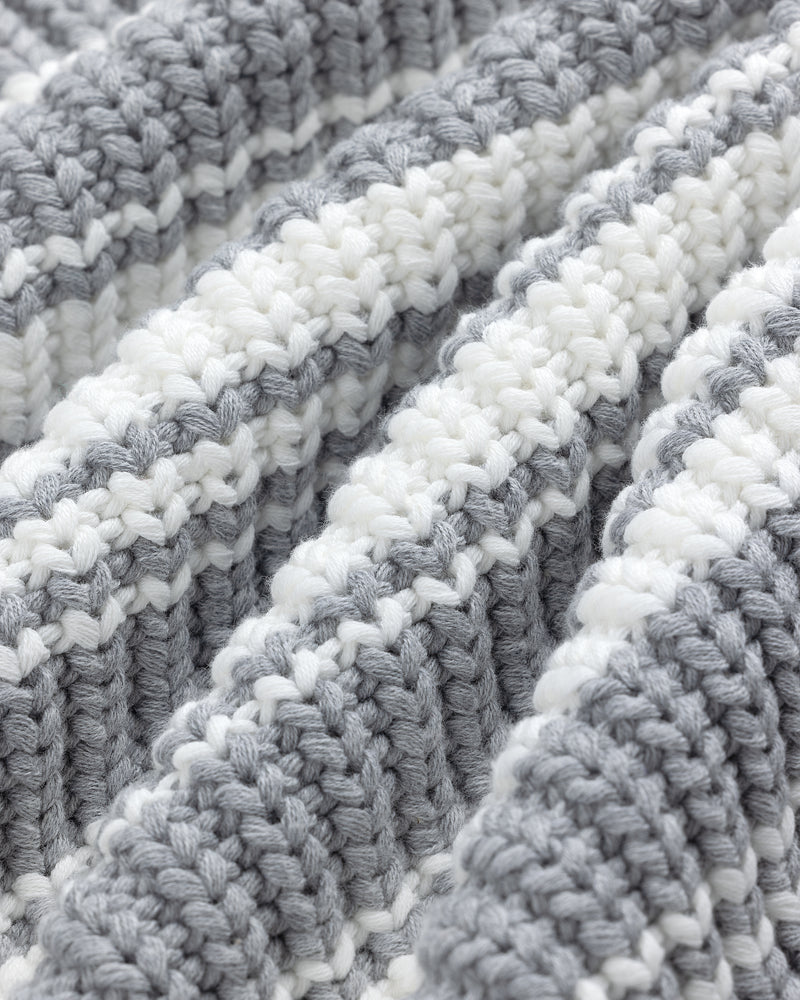 Close-up of the Striped Crewneck Sweater's textured fabric with alternating white and gray horizontal stripes.