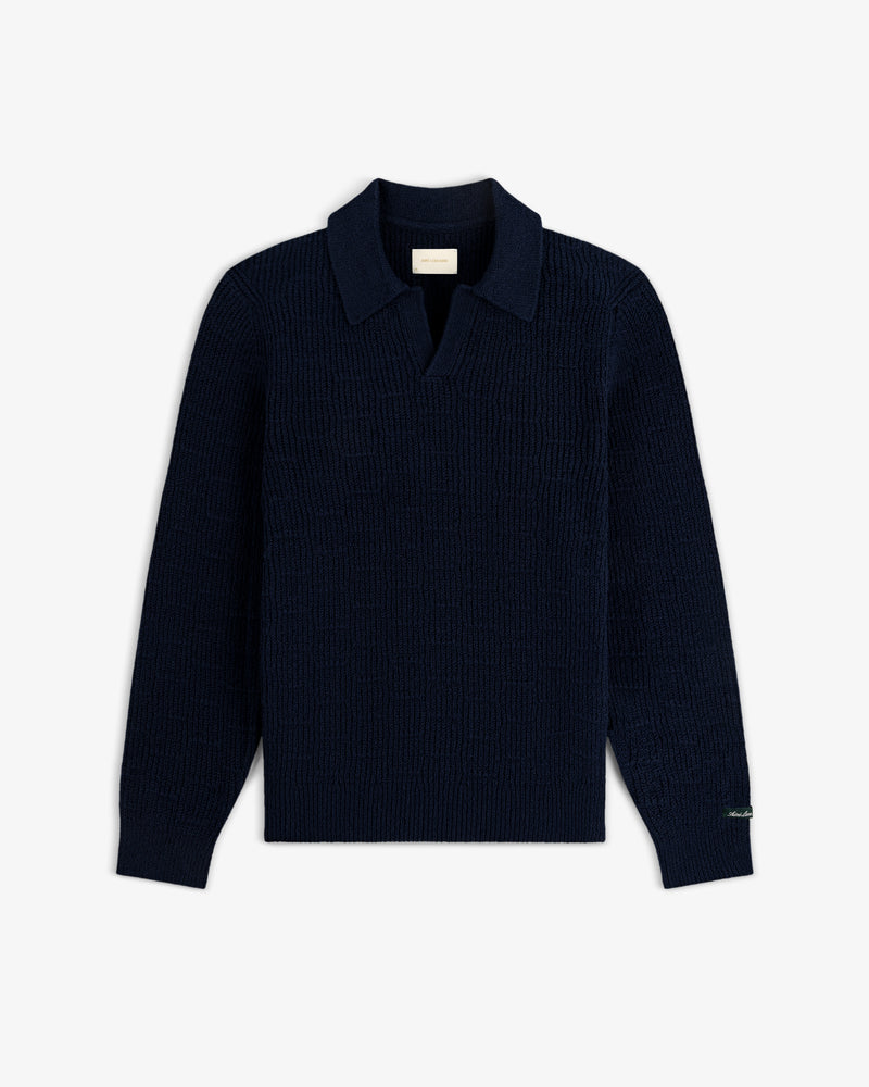 Long-Sleeve Boucle Polo in navy blue with collar and open placket, laid flat on a white background.