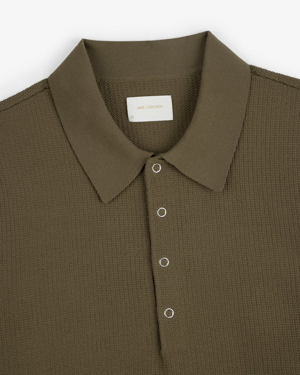 Olive green Knit Polo with four silver snap buttons and textured fabric, shown from above on a white background.