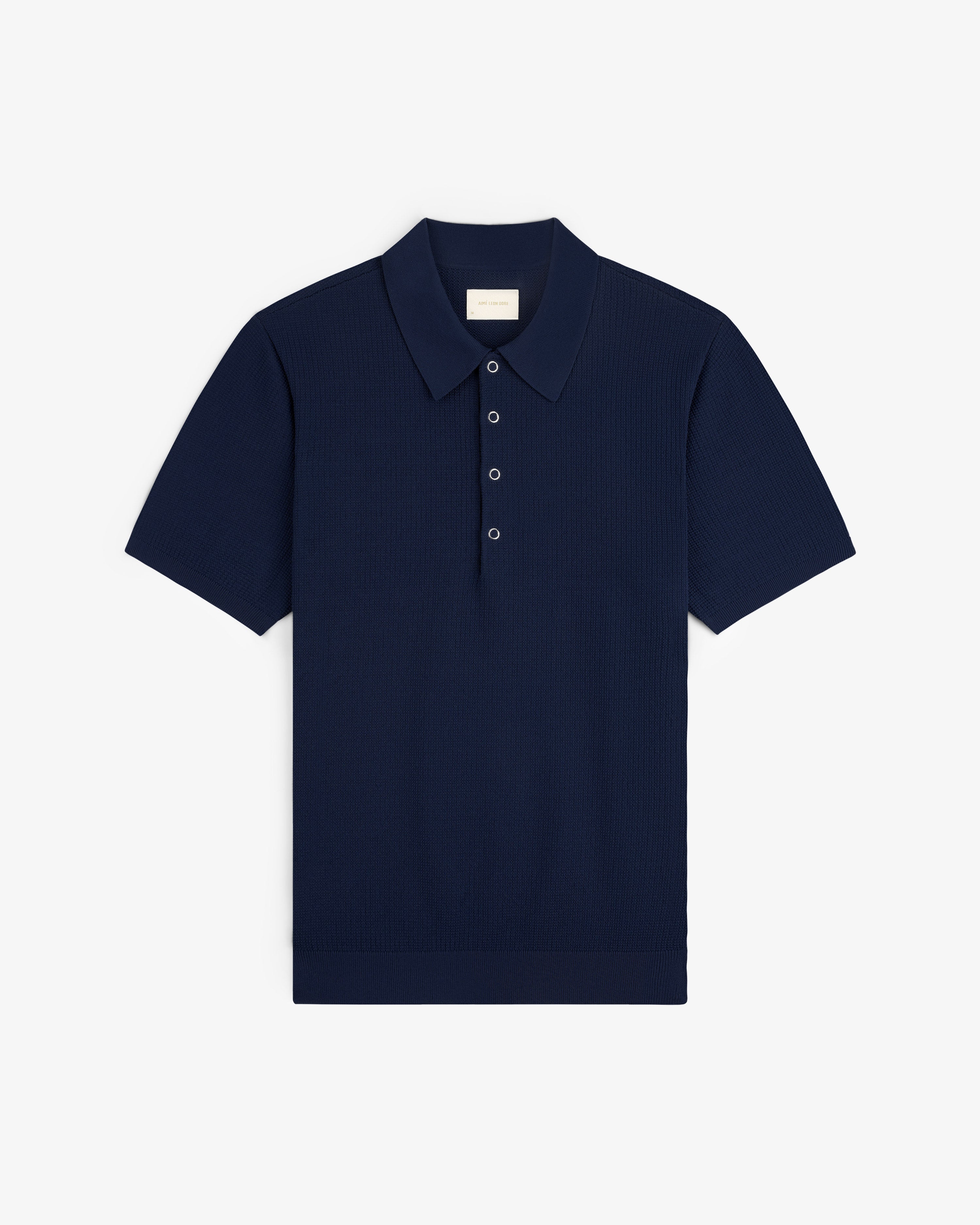 Navy blue Knit Polo with short sleeves, classic collar, and three buttons, shown flat on a white background.