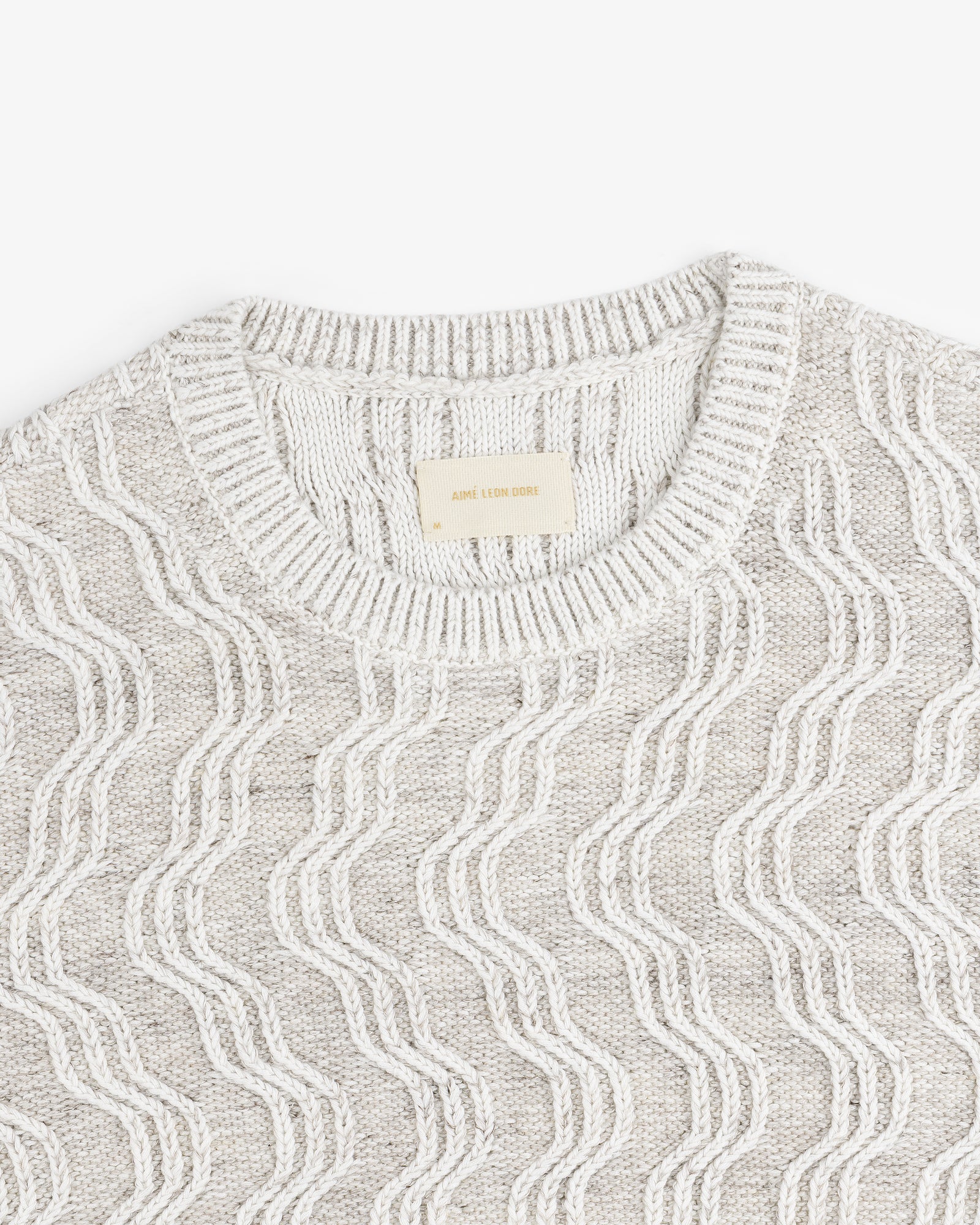 Linen Blend Cable Knit Sweater in beige with a wavy pattern and ribbed crew neckline, laid flat.