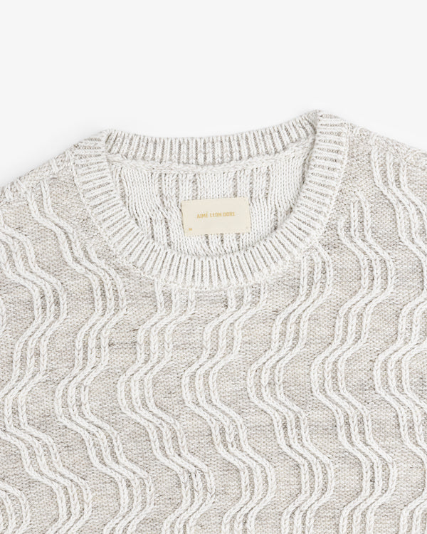 Linen Blend Cable Knit Sweater in beige with a wavy pattern and ribbed crew neckline, laid flat.
