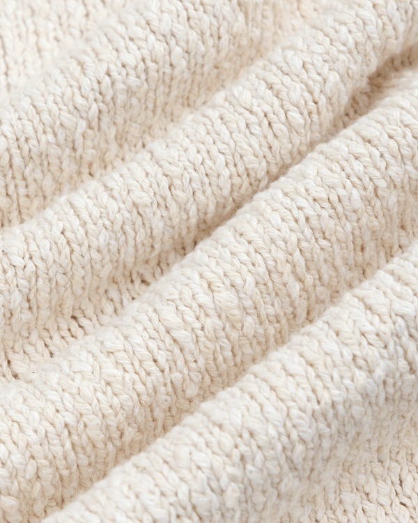 Close-up of the Cotton Slub Cardigan's soft, cream knit fabric with a ribbed, textured pattern.
