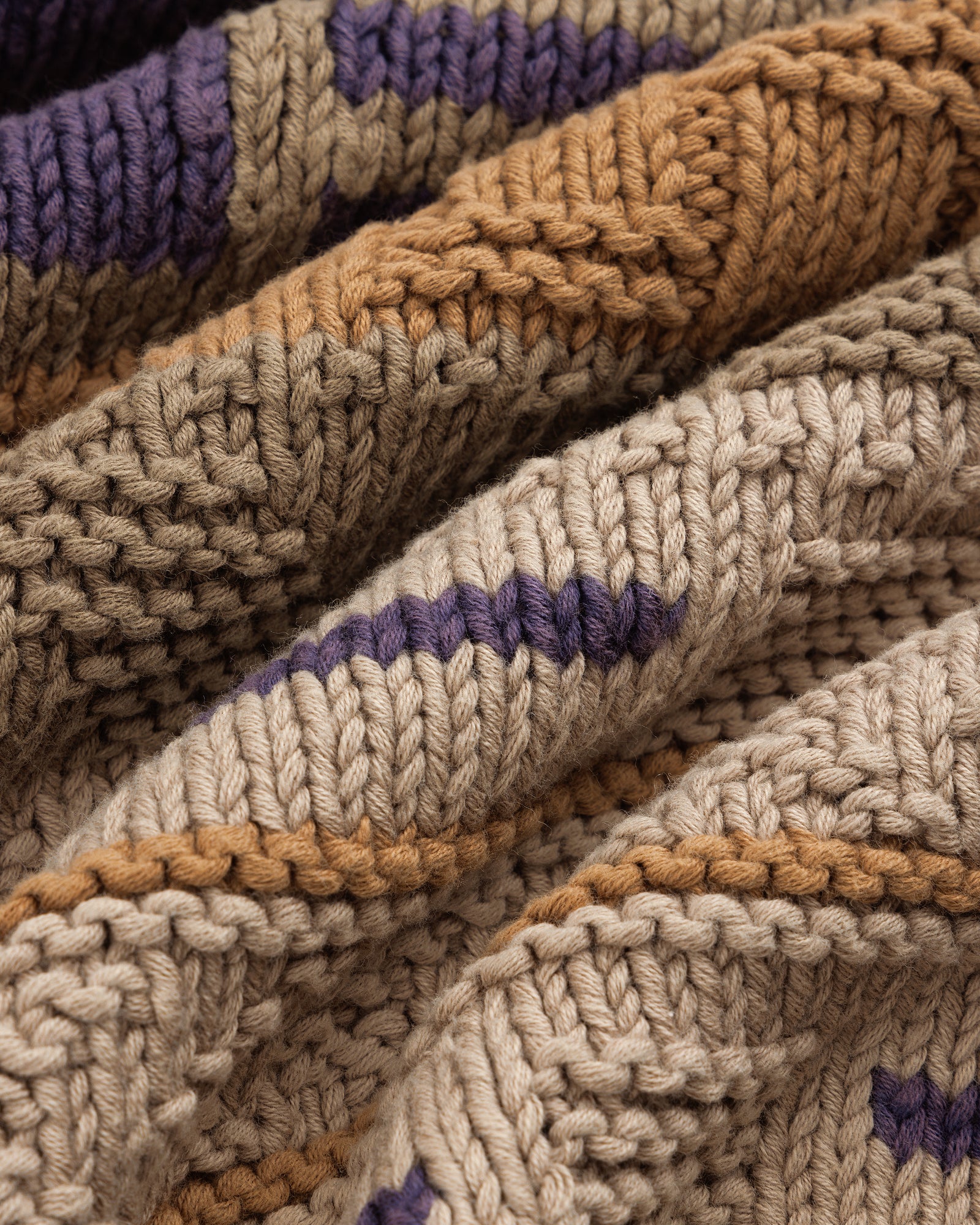 Close-up of the Simaía Crewneck Sweater featuring beige, brown, and purple stripes with textured, raised patterns.