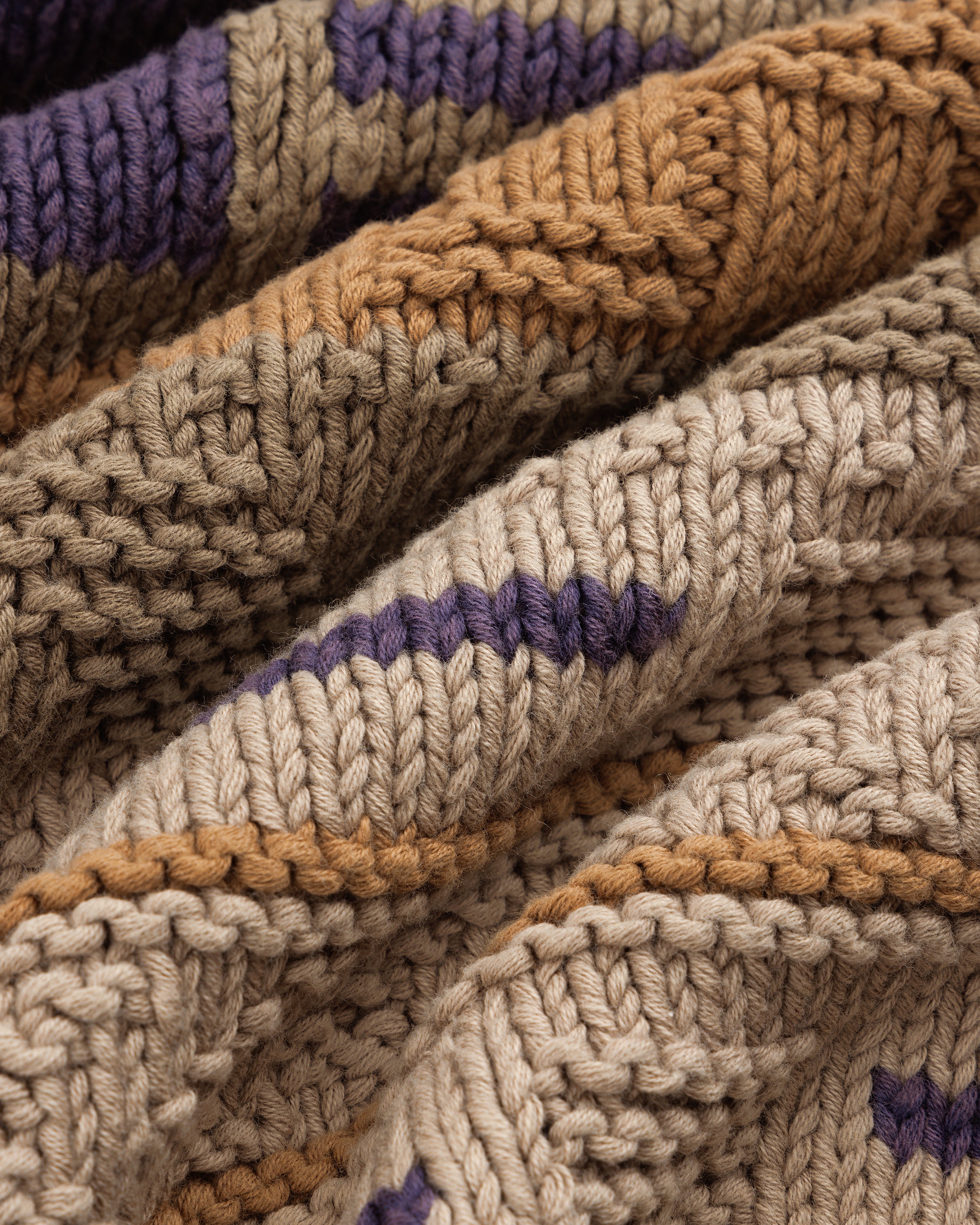 Close-up of the Simaía Crewneck Sweater featuring beige, brown, and purple stripes with textured, raised patterns.