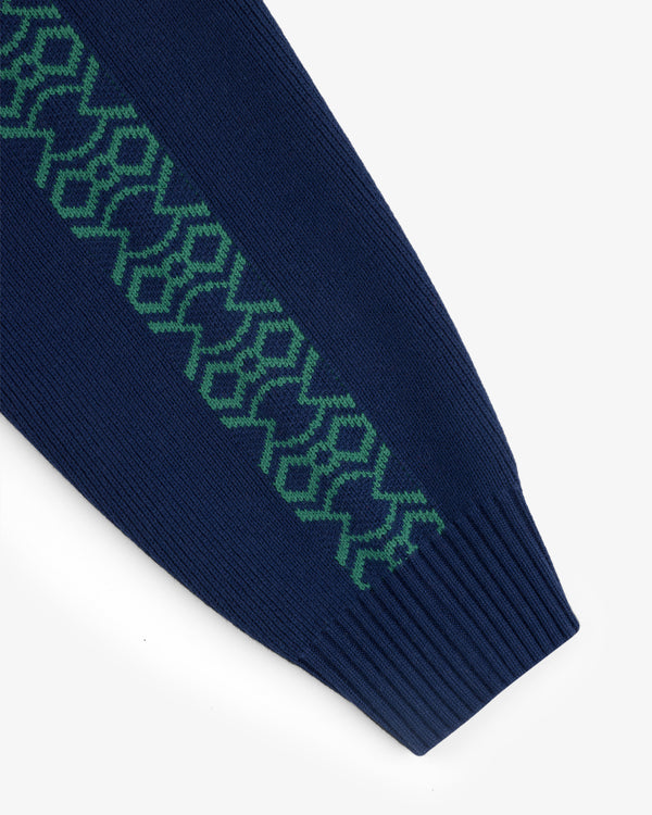 Close-up of Knit Sport Pullover's navy sleeve with a green geometric zigzag pattern along the arm.