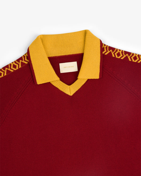 Knit Sport Pullover in maroon with a gold collar and gold patterned shoulder detailing.
