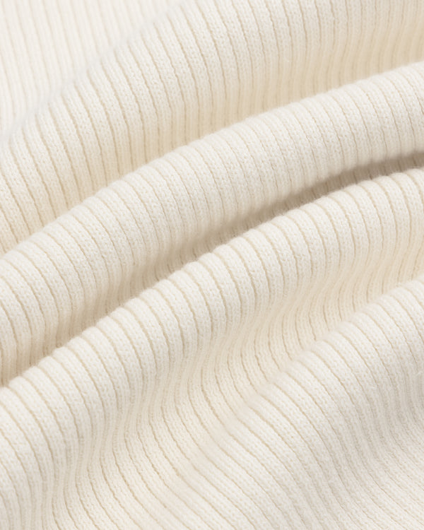 Close-up of the Sport Knit Henley’s cream ribbed fabric with soft folds and textured vertical lines.