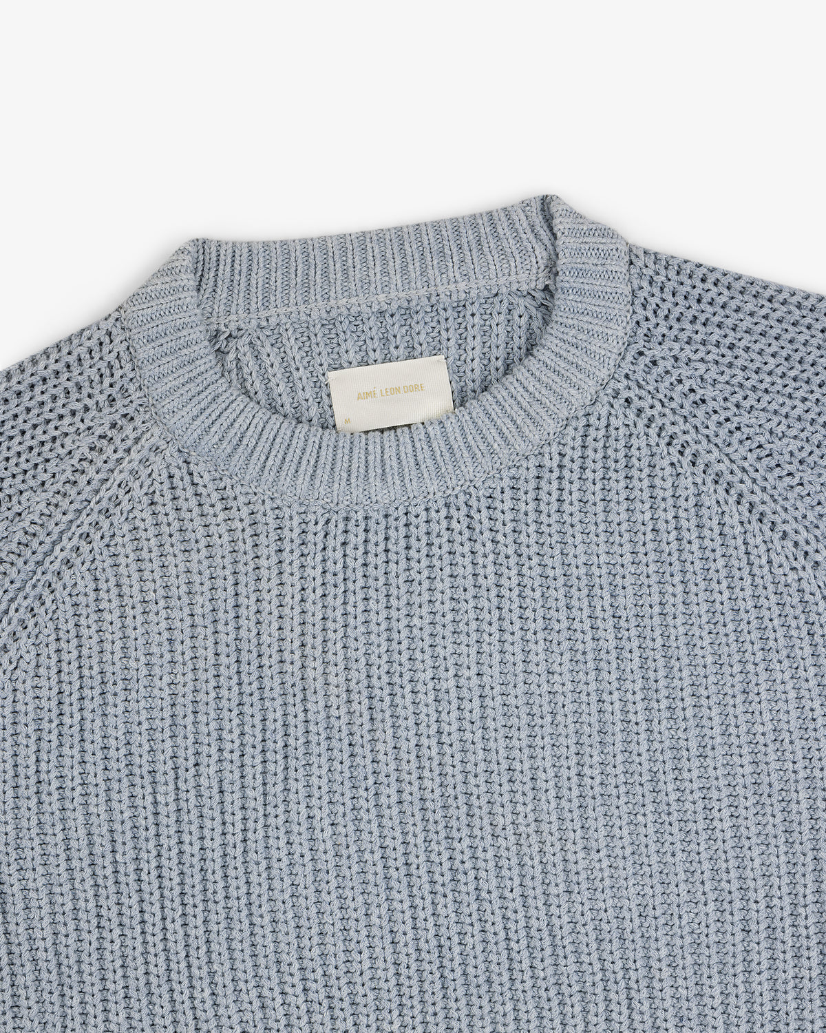 Knit Denim Crewneck Sweater with a ribbed neckline and textured pattern, shown on a white background.