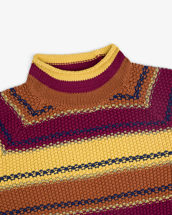 A close-up of the Striped Rollneck Sweater with yellow, maroon, brown, and navy blue stripes and a ribbed collar.