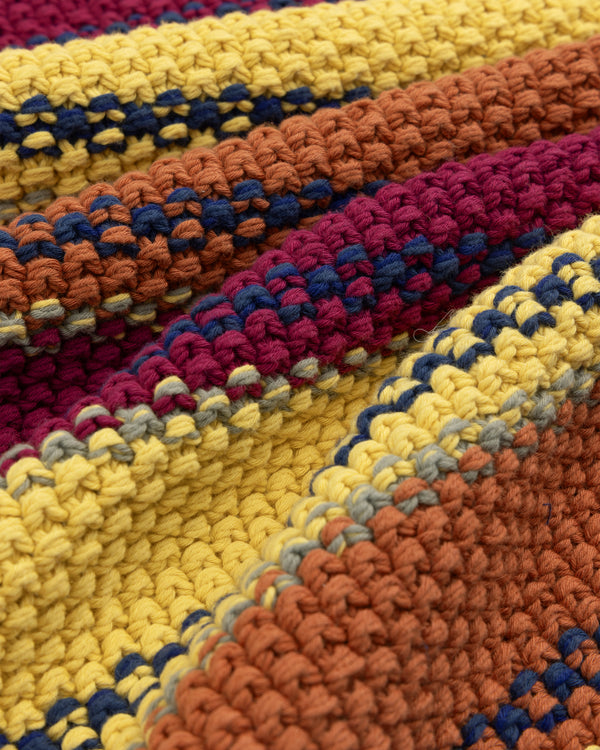 Close-up of the Striped Rollneck Sweater featuring orange, yellow, burgundy, and navy blue crochet stripes.