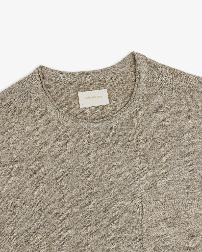A close-up of a light gray Long-Sleeve Knit Pocket Tee with a visible beige label inside the collar.