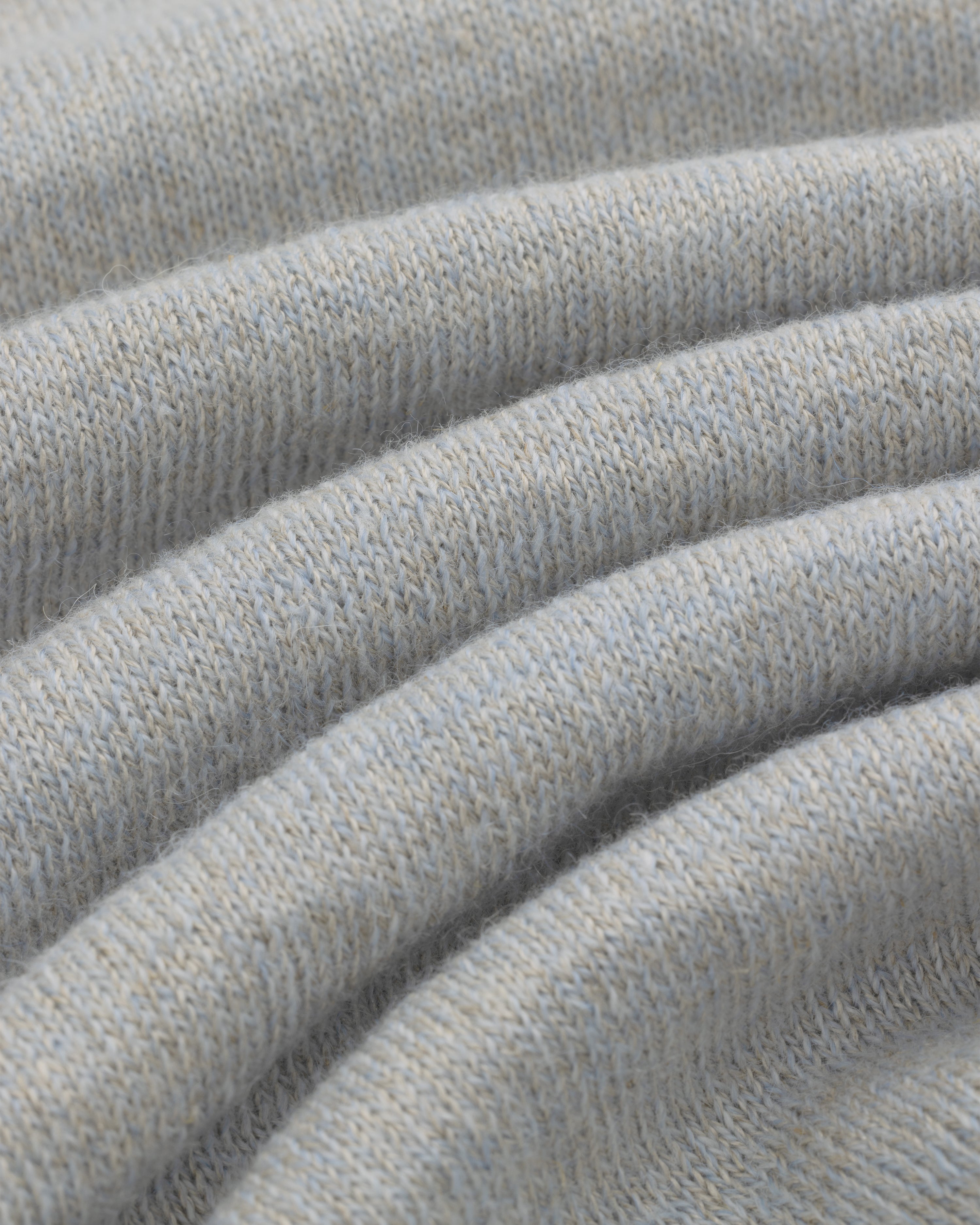 Close-up of soft, light gray Long-Sleeve Knit Pocket Tee fabric with visible texture and gentle folds.