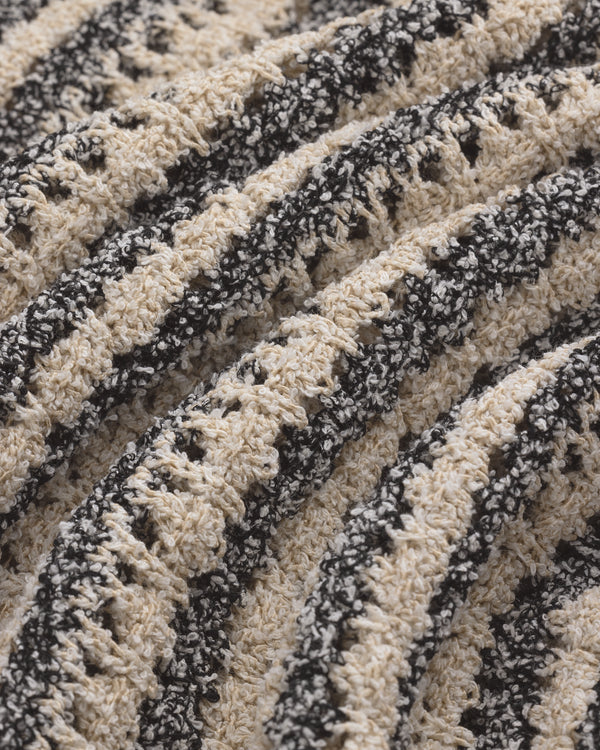 Close-up of the Bouclé Open Knit Crewneck Sweater’s cream and black wavy striped crochet texture.