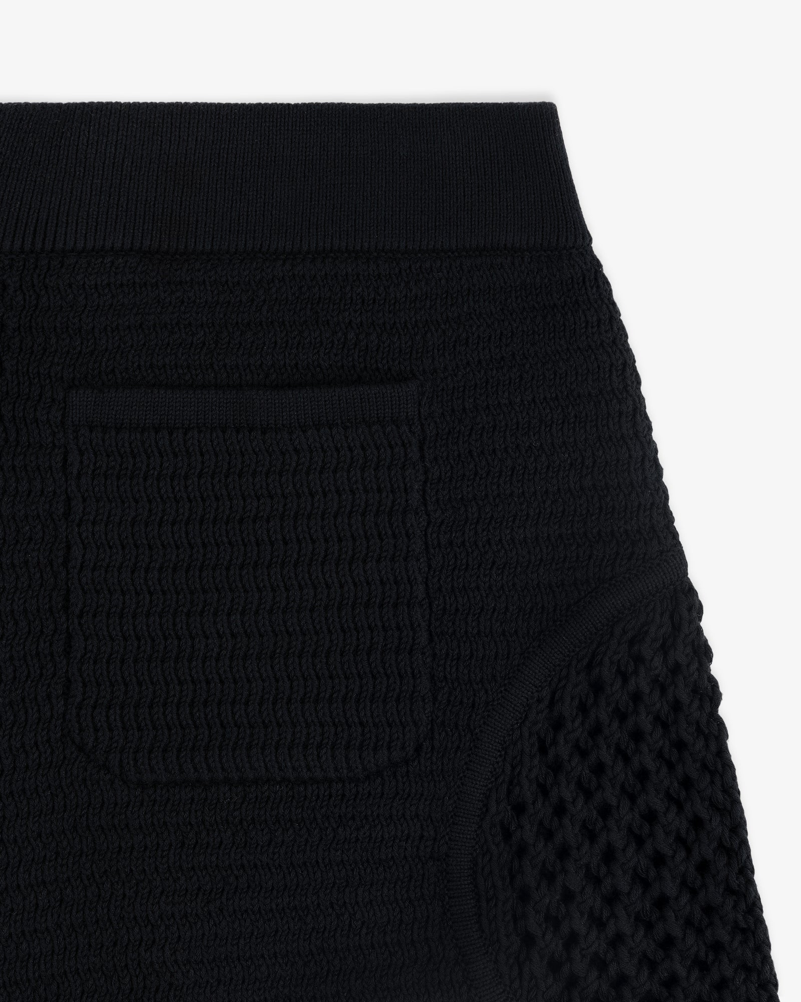 Close-up of the Knit Court Short in textured black knit, featuring a small pocket and ribbed waistband.