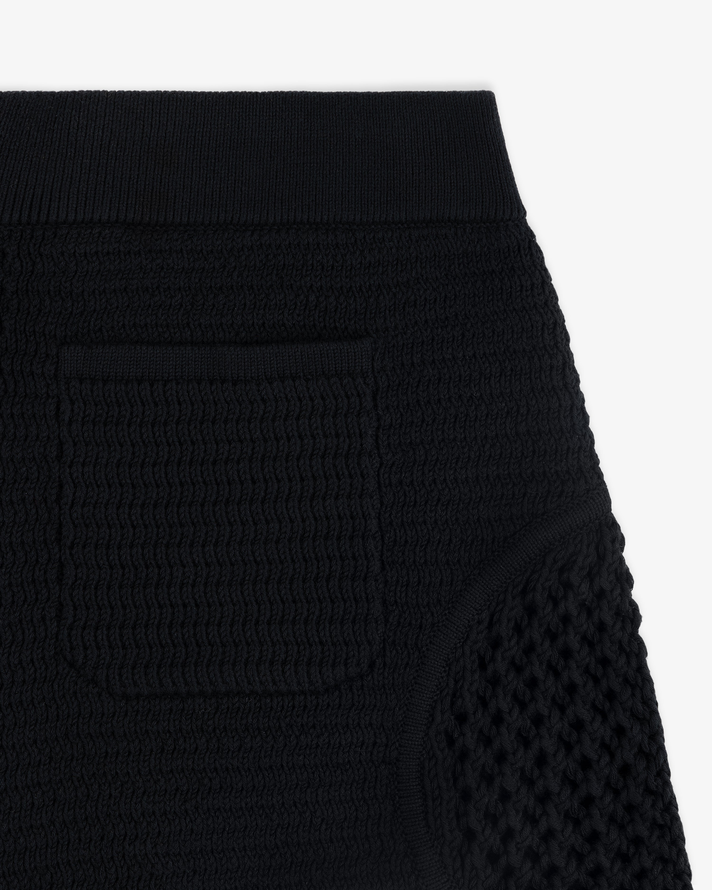 Close-up of the Knit Court Short in textured black knit, featuring a small pocket and ribbed waistband.