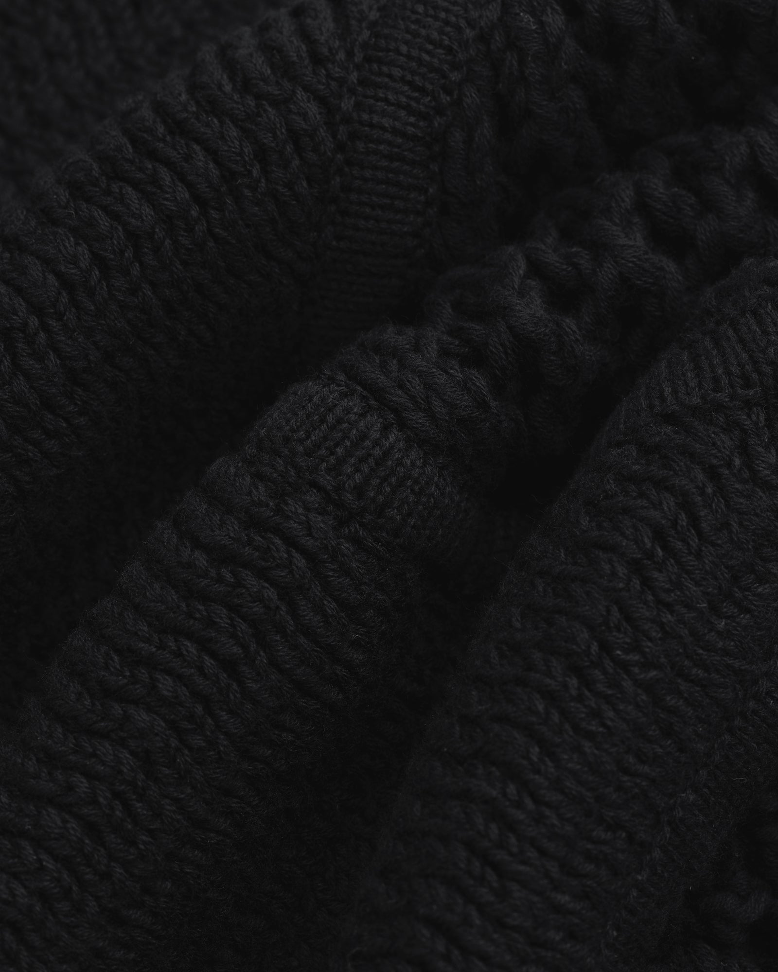 Close-up of black Knit Court Short fabric with visible textured patterns and folds.