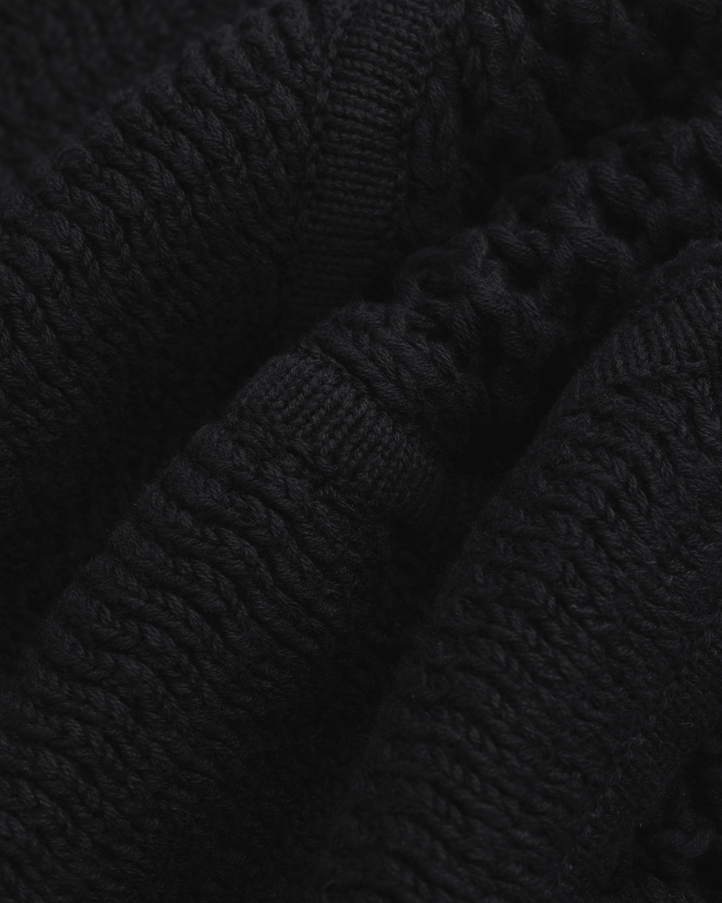 Close-up of black Knit Court Short fabric with visible textured patterns and folds.