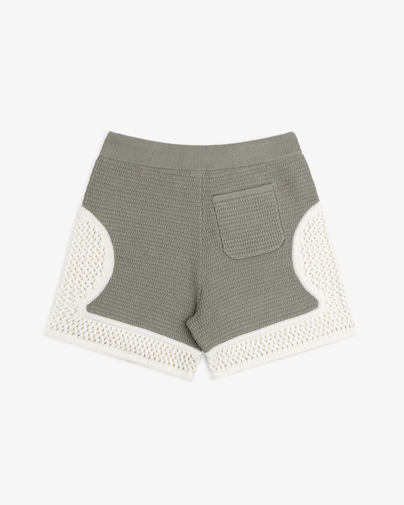 Knit Court Short in green with a back pocket and white crochet trim on sides and hem, shown on a white background.