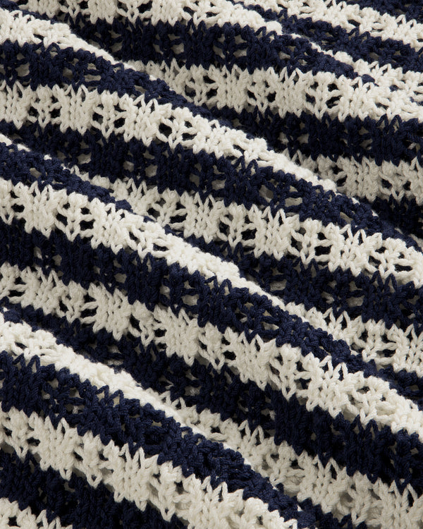 Close-up of the Skáfos Sweater’s textured fabric with diagonal navy and white crocheted stripes.