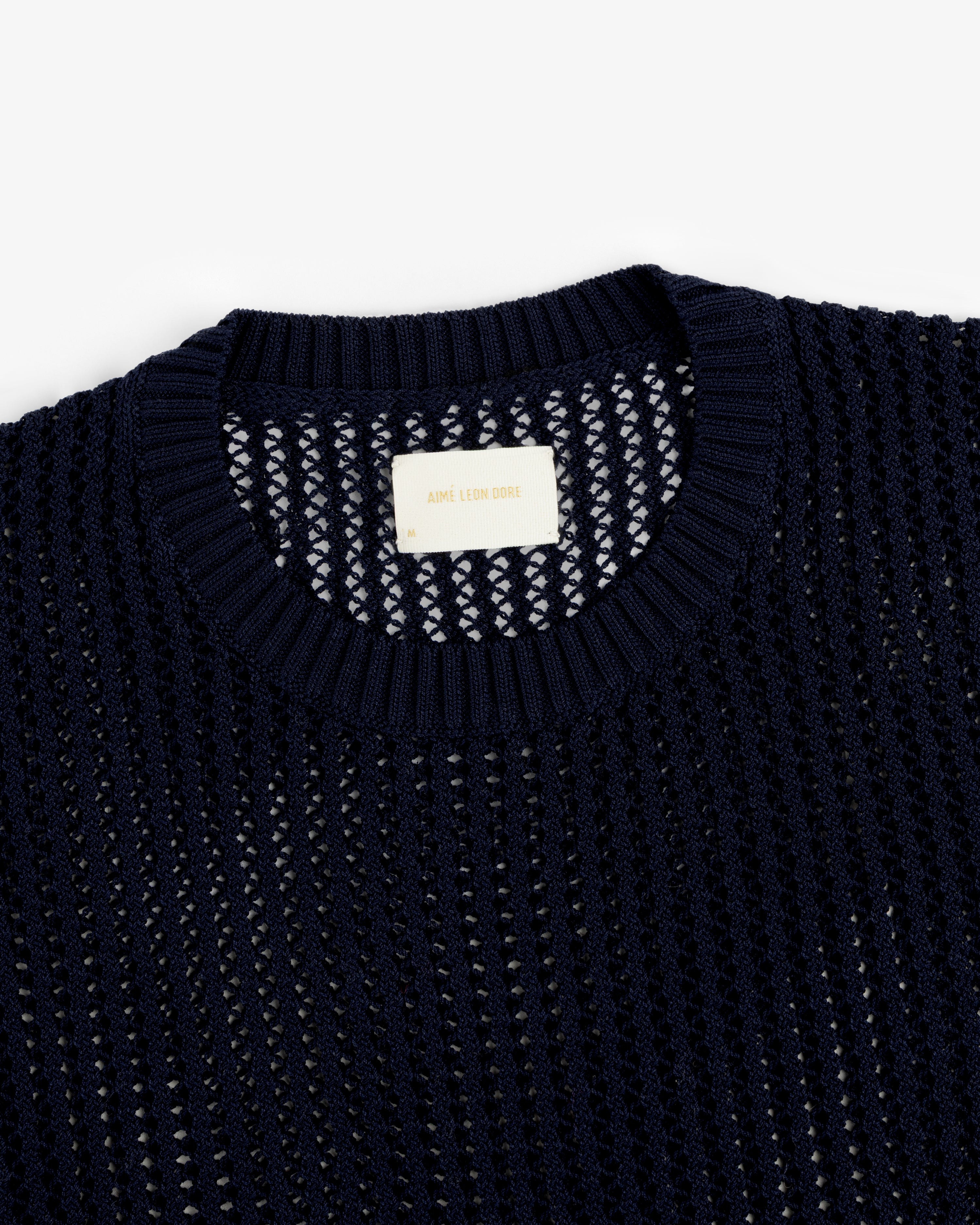 Navy blue Cotton Eyelet Crewneck Sweater with “Aimé Leon Dore” label on the inside collar.