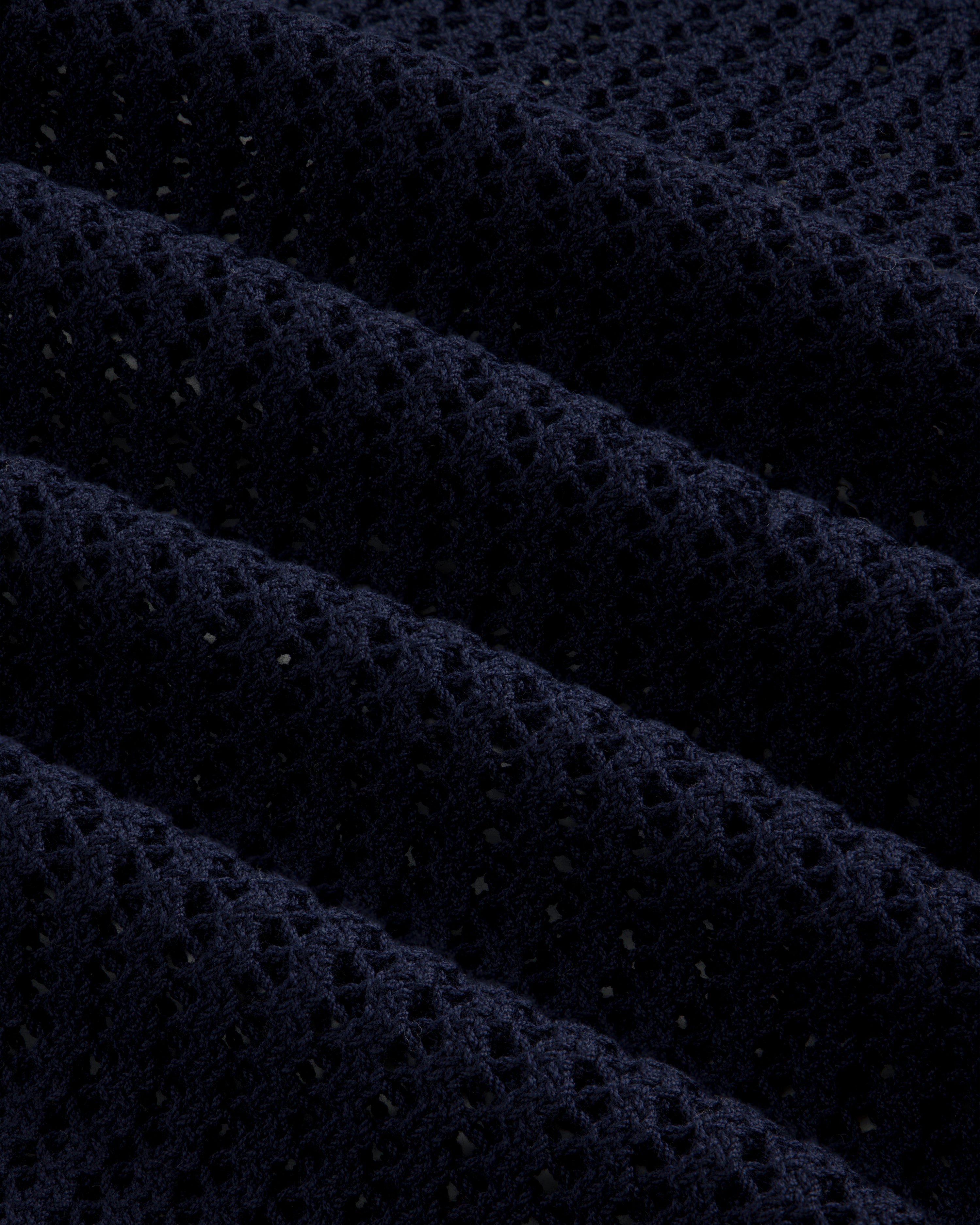 Close-up of Cotton Eyelet Crewneck Sweater in dark blue, featuring small holes and raised textured ridges.