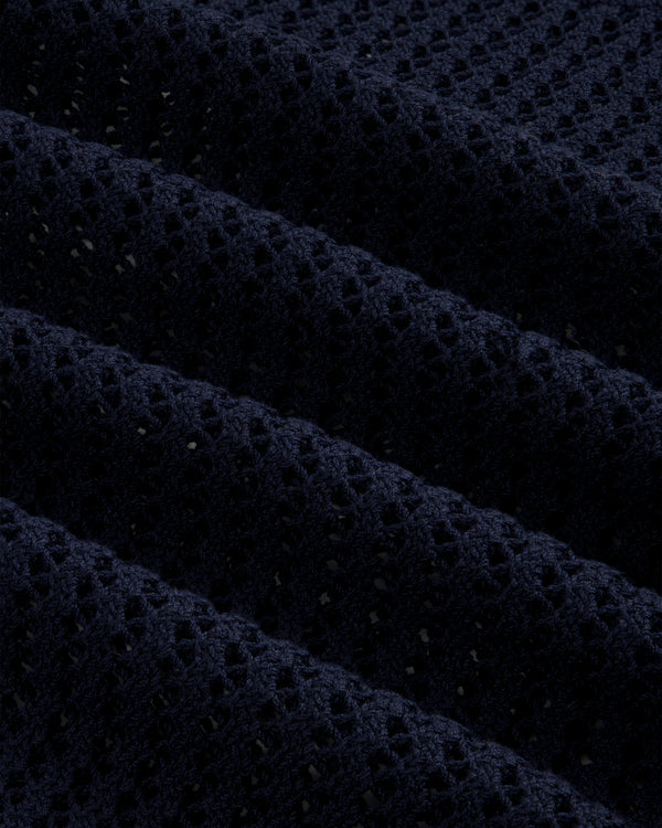 Close-up of Cotton Eyelet Crewneck Sweater in dark blue, featuring small holes and raised textured ridges.