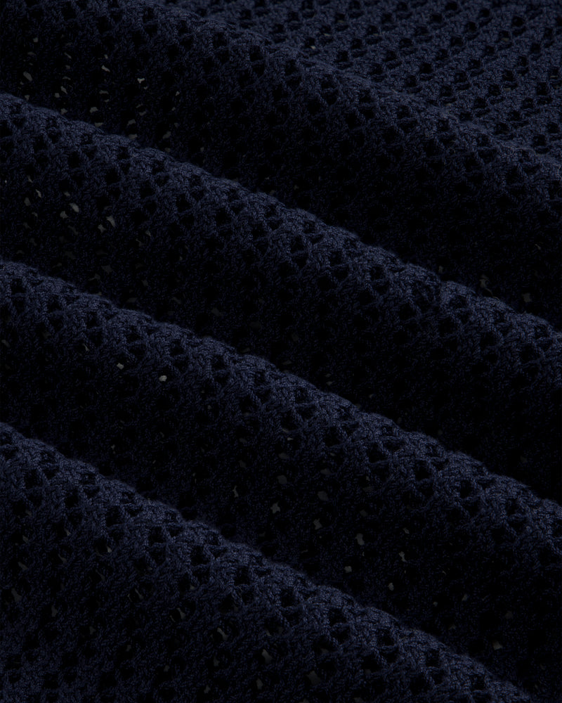 Close-up of Cotton Eyelet Crewneck Sweater in dark blue, featuring small holes and raised textured ridges.