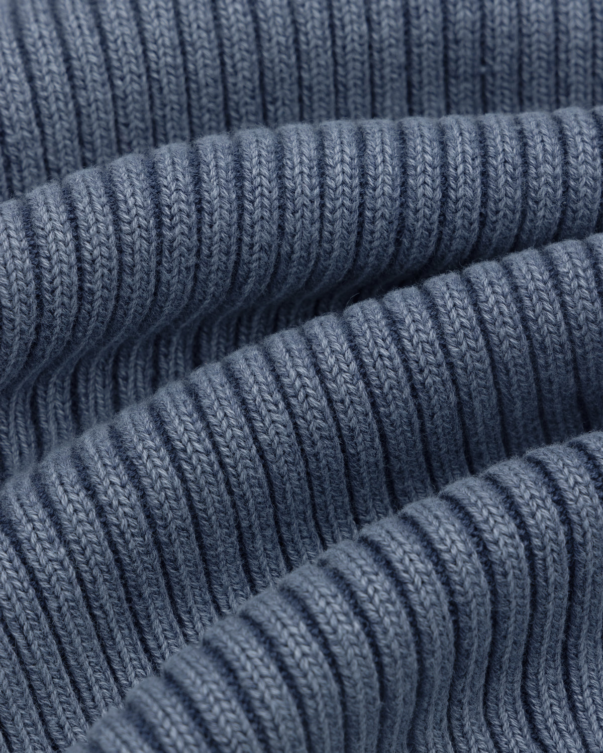 Close-up of Stone Washed Knit Tank Top in blue, showing ribbed fabric with wavy folds and detailed stitching.