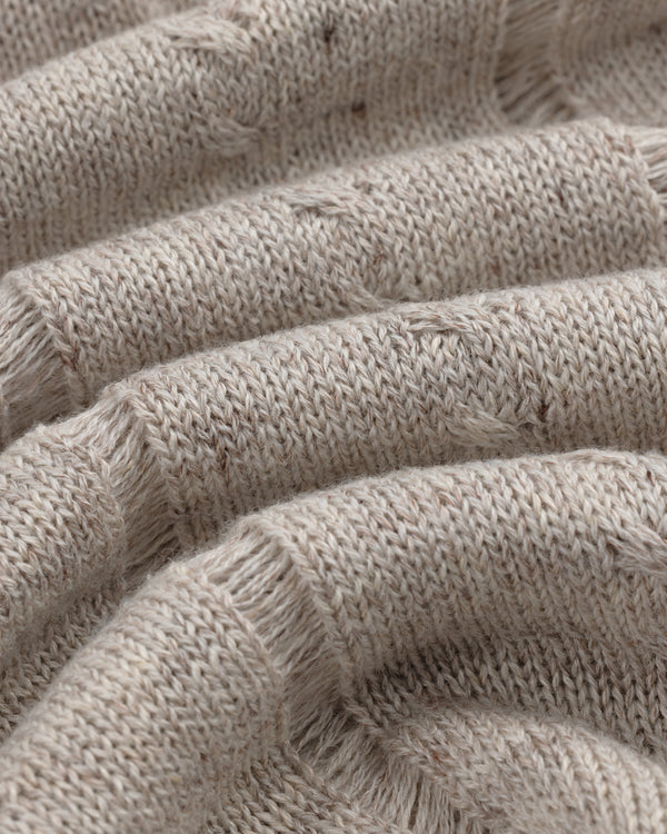 Close-up of a Pointelle Tank Top in beige knit with ribbed texture, visible stitches, and soft wavy folds.