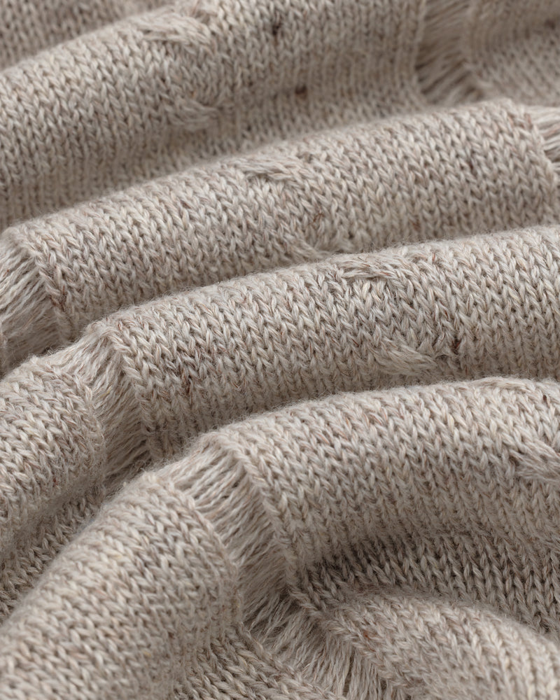Close-up of a Pointelle Tank Top in beige knit with ribbed texture, visible stitches, and soft wavy folds.