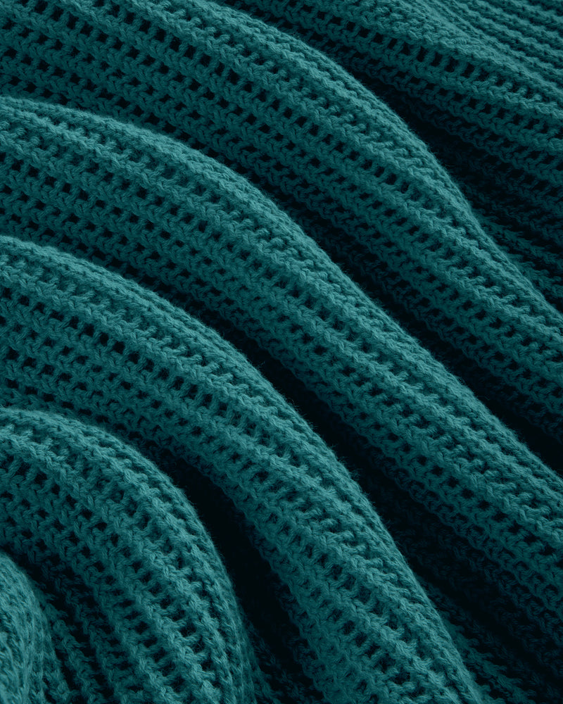 Close-up of the Mesh Knit Polo in teal, featuring a textured, wavy knit pattern with ridges and rows.