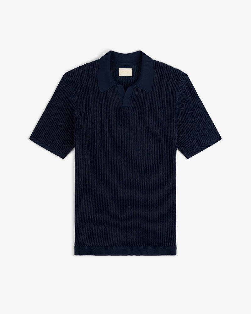Mesh Knit Polo in navy blue with short sleeves, ribbed texture, and open collar, shown flat on a white background.