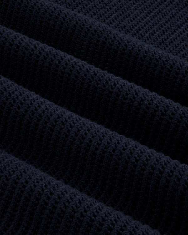 Close-up of dark blue Mesh Knit Polo, highlighting ribbed texture with horizontal ridges and soft material detail.