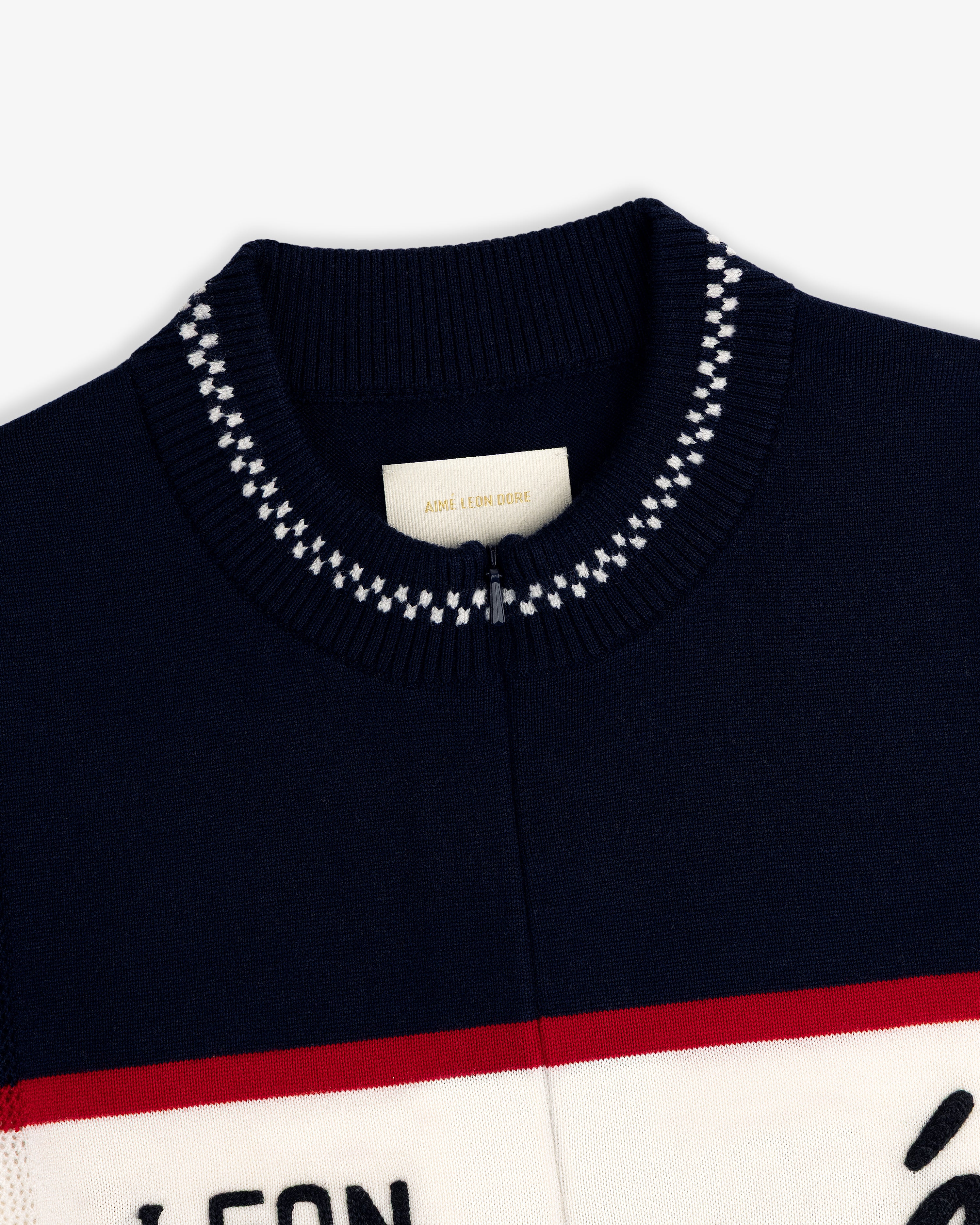 Close-up of a navy Merino Wool Cycling Jersey collar with white stitching and an Aimé Leon Dore label inside.