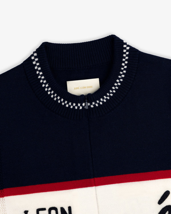 Close-up of a navy Merino Wool Cycling Jersey collar with white stitching and an Aimé Leon Dore label inside.