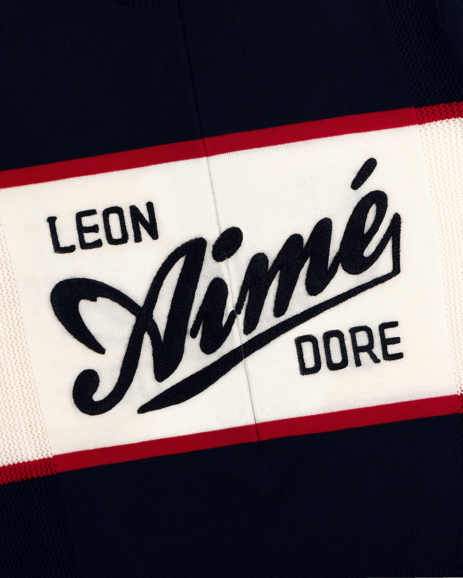 Navy Merino Wool Cycling Jersey with LEON Aimé DORE in bold white, black, and red letters, edged with red stripes.