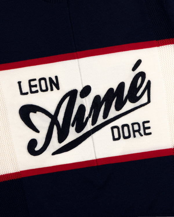 Navy Merino Wool Cycling Jersey with LEON Aimé DORE in bold white, black, and red letters, edged with red stripes.