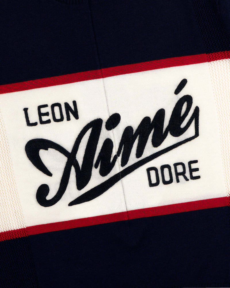 Navy Merino Wool Cycling Jersey with LEON Aimé DORE in bold white, black, and red letters, edged with red stripes.