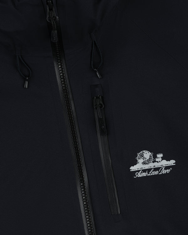Close-up of the Lightweight GORE-TEX Shell Jacket with a globe logo and Aimé Leon Dore text by the zippered chest pocket.