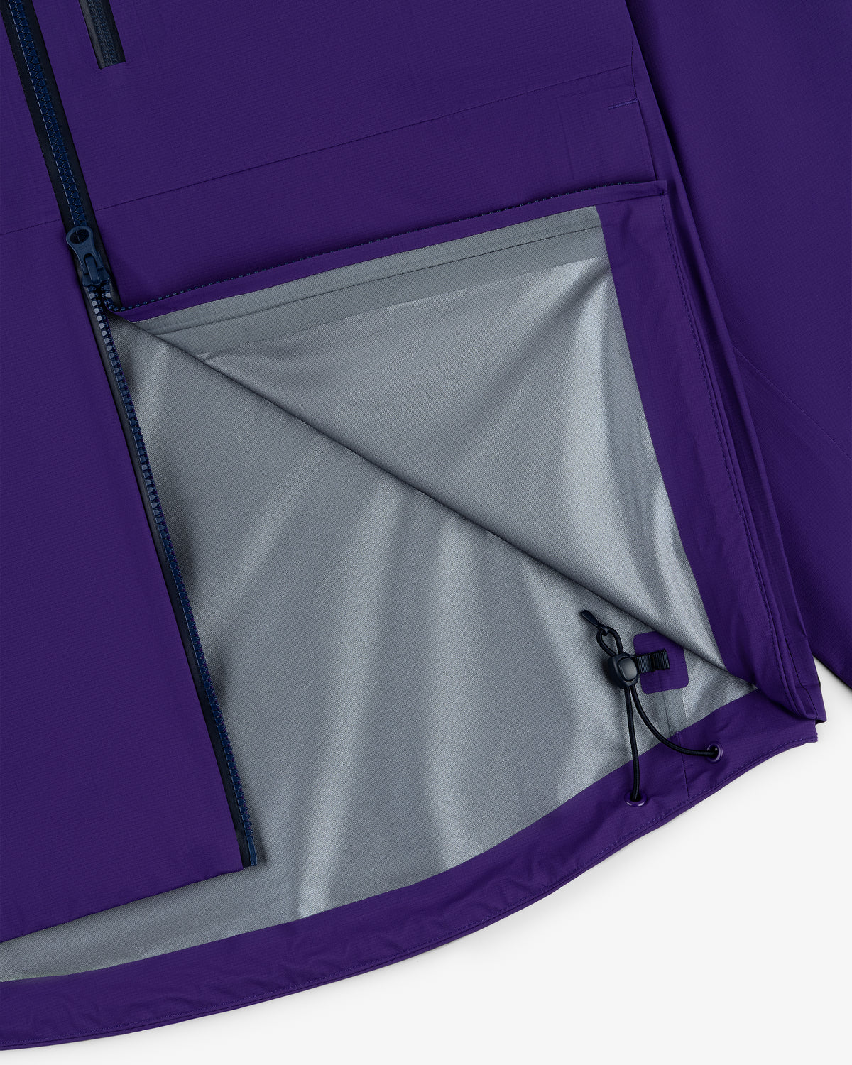 Close-up of the Lightweight GORE-TEX Shell Jacket’s purple interior pocket, grey lining, and adjustable drawstring hem.