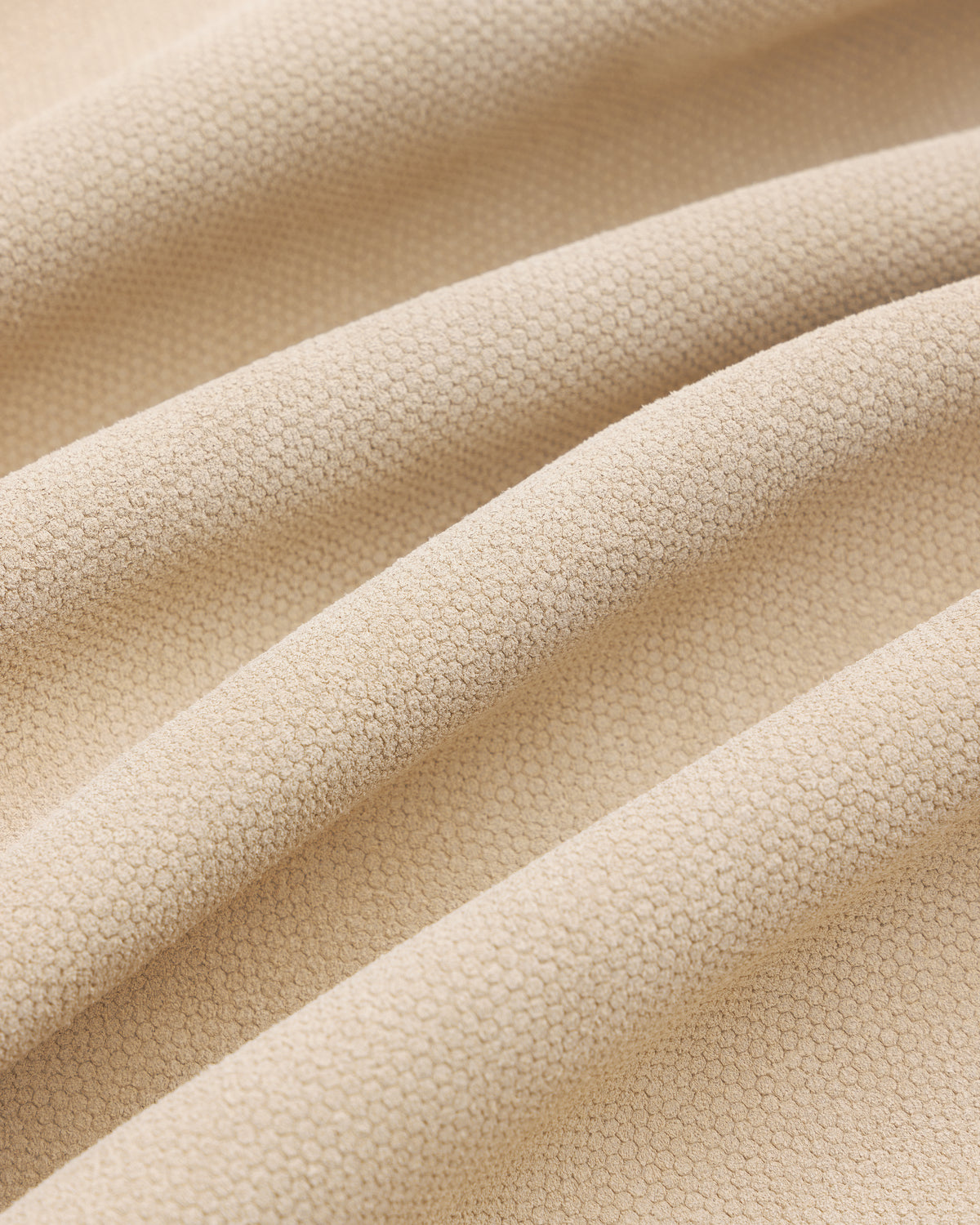 Close-up of the Leather Ranch Jacket's beige textured fabric with small hexagonal patterns and gentle folds.